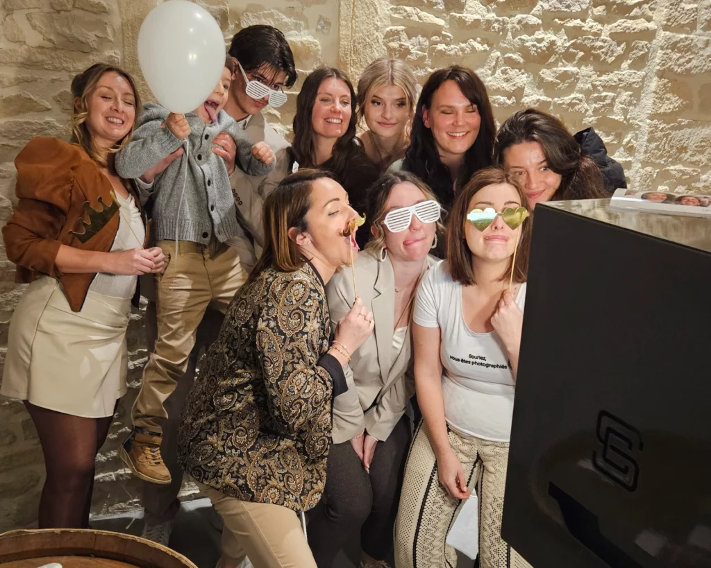 Groupe d'amis faisant des photos devant une borne photo pour un mariage