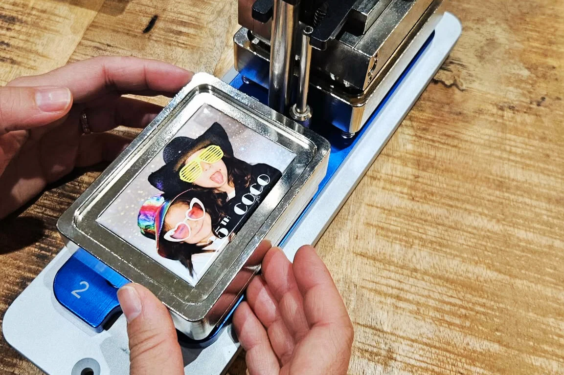 Fabrication de magnets en direct pour cadeau personnalisé invité. Mains qui sont en train de faire le magnet en live